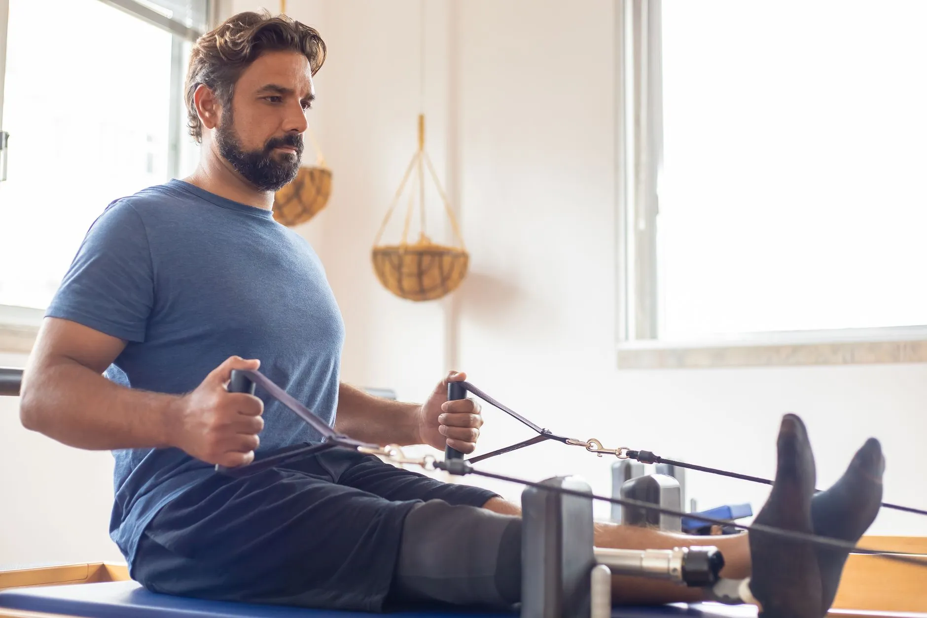 A man doing a controlled band row on a training machine