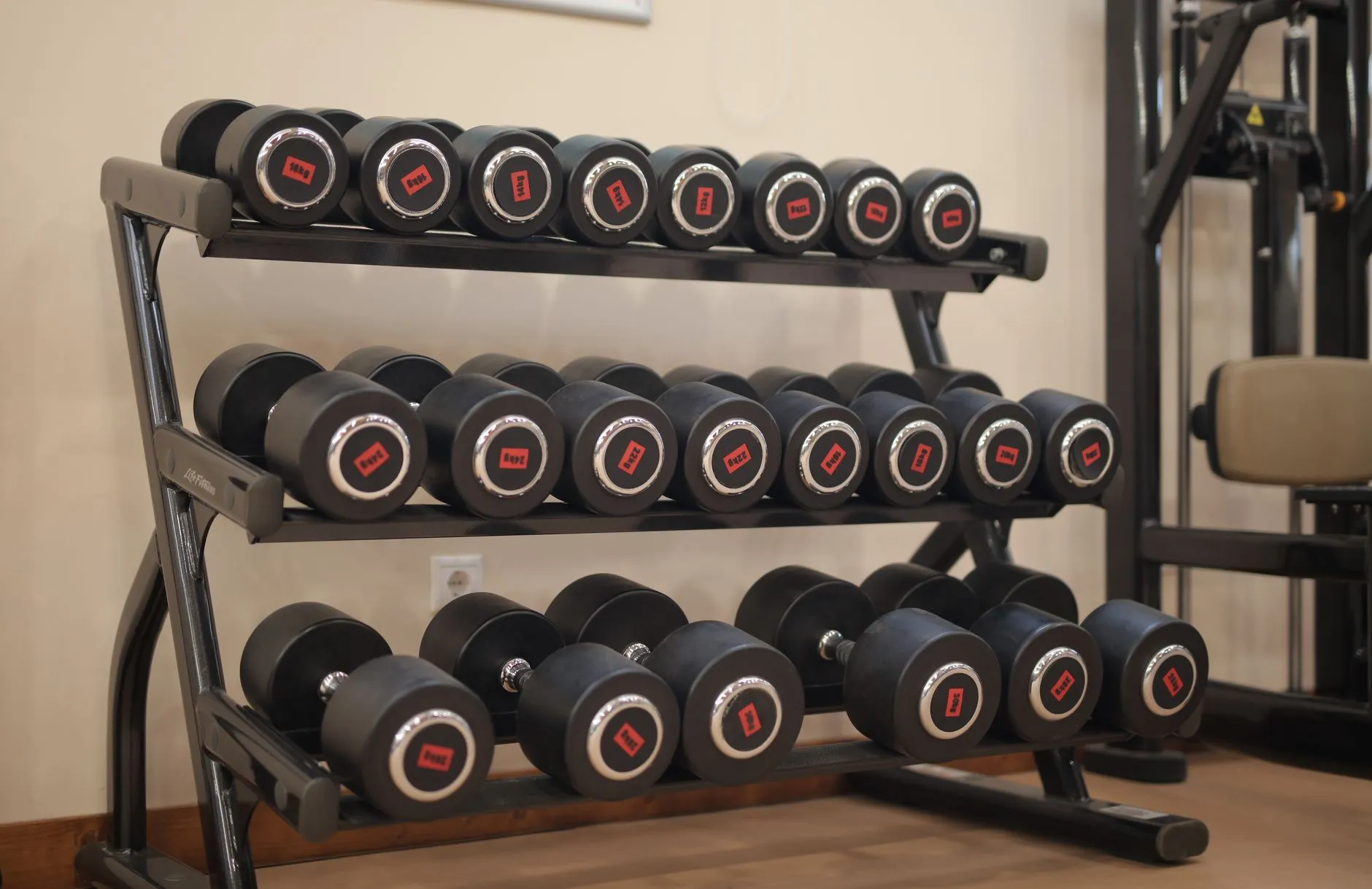 A dumbbell rack in a small hotel gym