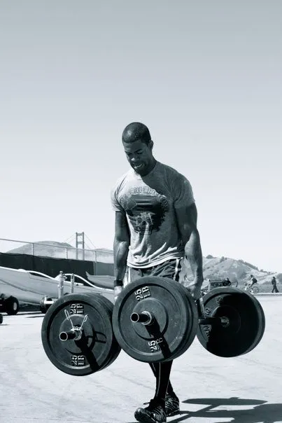 Dr. LaMar Sheppard carrying loaded barbells in San Francisco