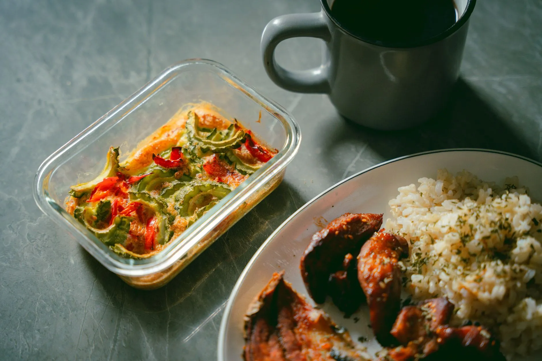 A prepared meal of vegetables and rice in a glass container