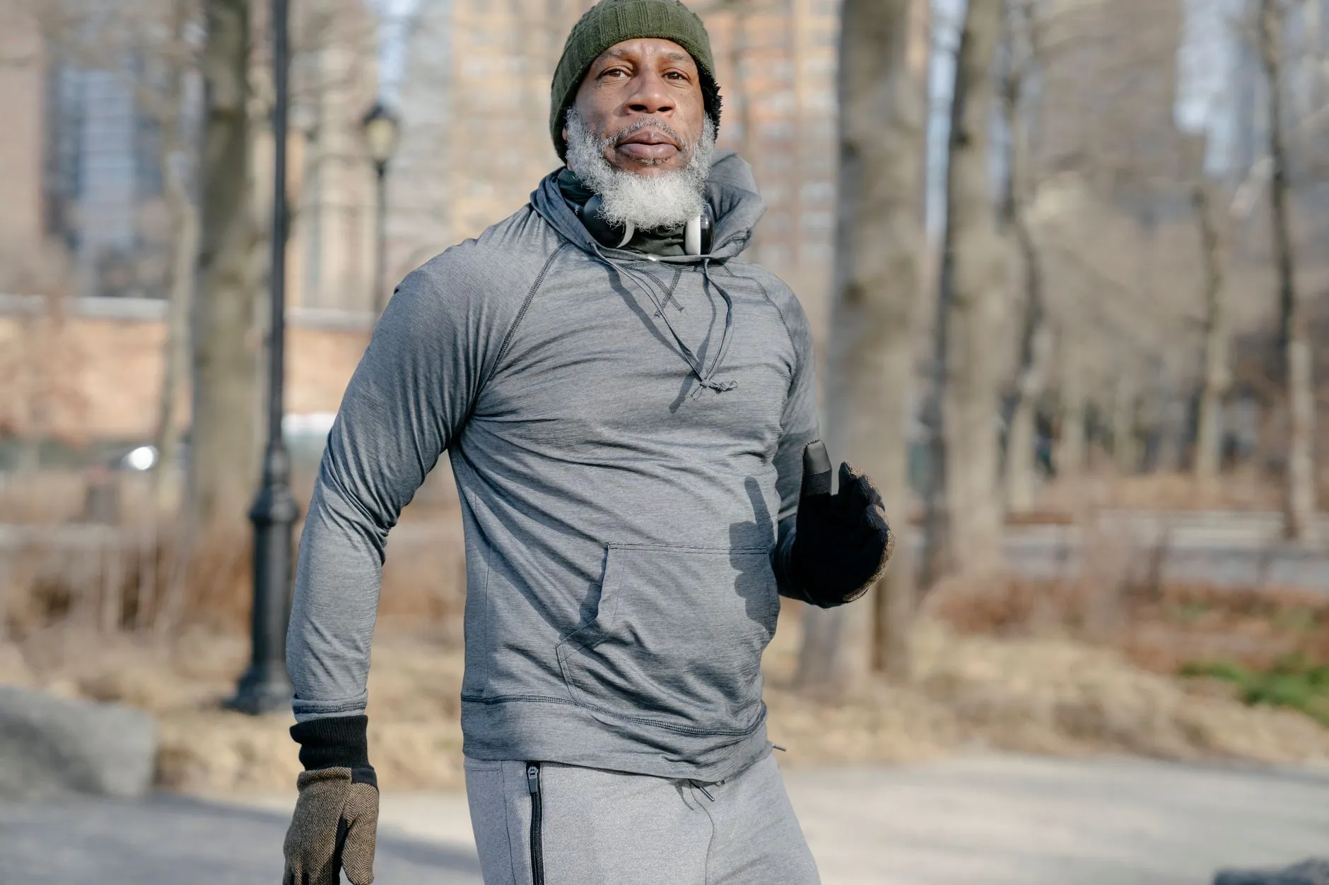 A fit grey-bearded man out for a run in the park