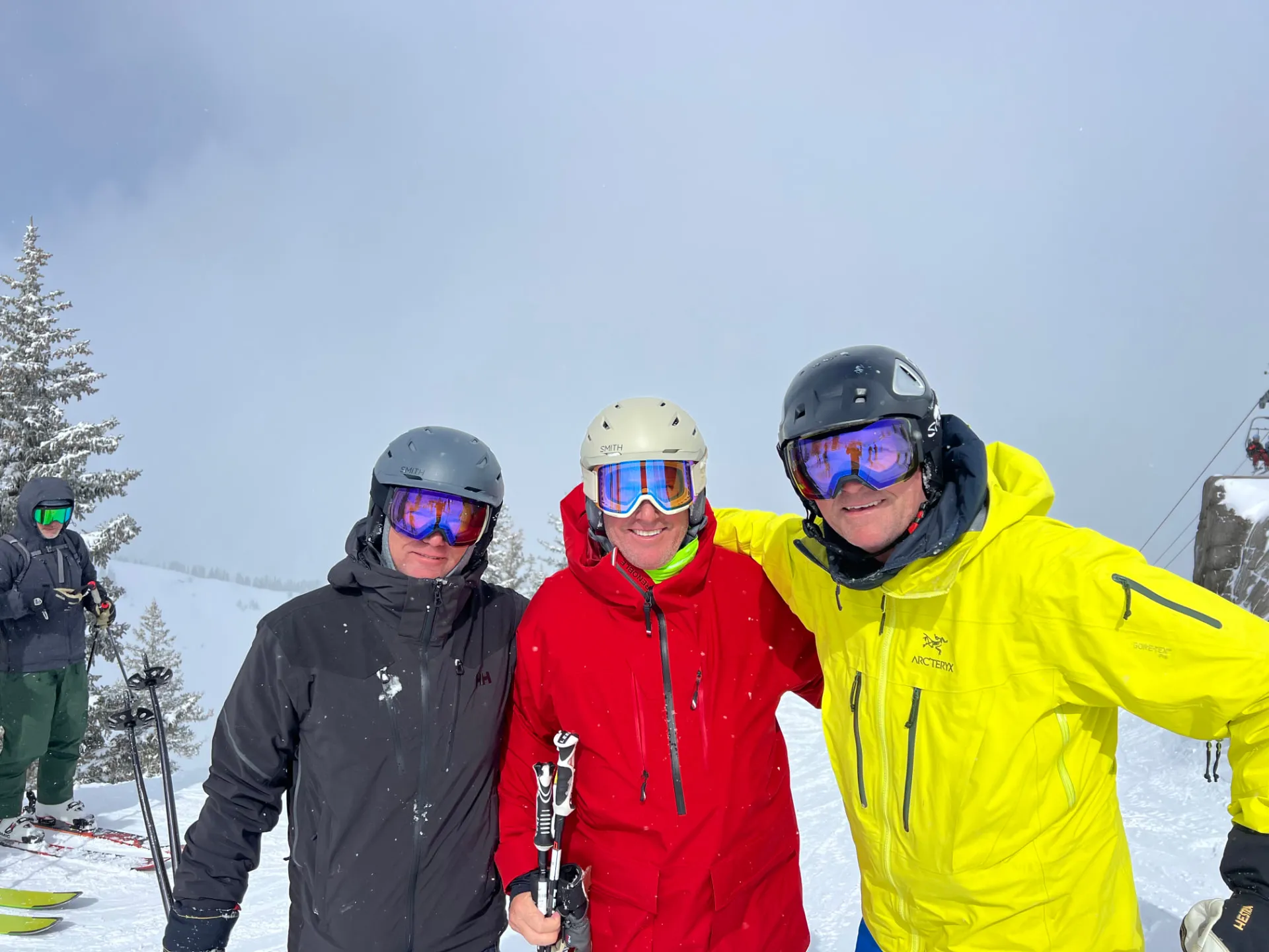 Three skiers on a snowy summit