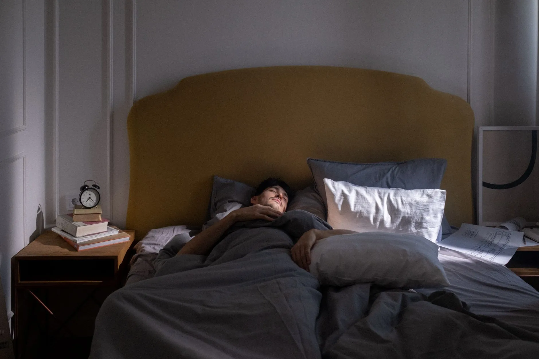 A man asleep in a dim bedroom