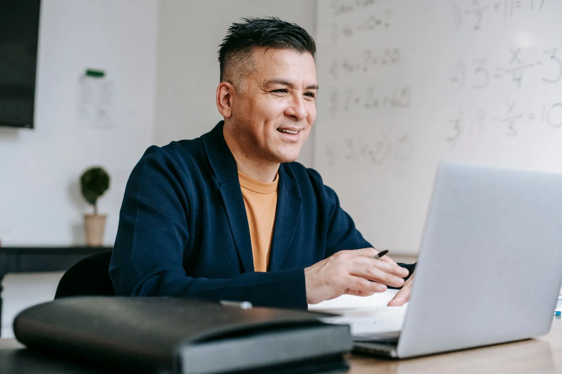 A smiling man on a video call at his laptop